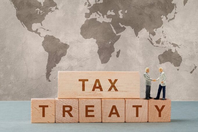Tax report concept with wooden blocks with words on it on sage c Tax Treaty